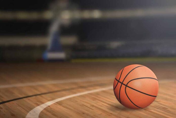 377181817 featured image Basketball on an indoor court, hoop in background.