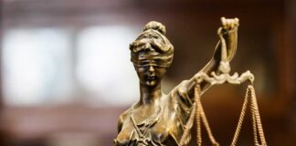 Bronze Lady Justice statue holding scales.