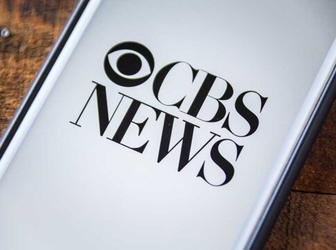 Phone screen showing CBS News logo.