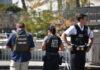 Authorities standing together outdoors wearing law enforcement gear