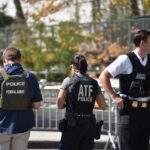 Authorities standing together outdoors wearing law enforcement gear