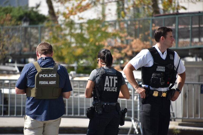 Authorities standing together outdoors wearing law enforcement gear