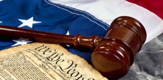 Gavel and Constitution on American flag background.