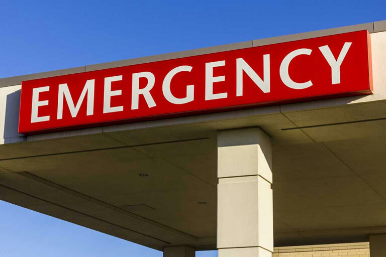 Red and white Emergency sign outside building.