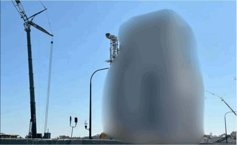 Construction site with cranes and equipment under a clear blue sky