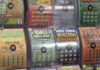 A display of various colorful lottery scratch-off tickets with different prize amounts