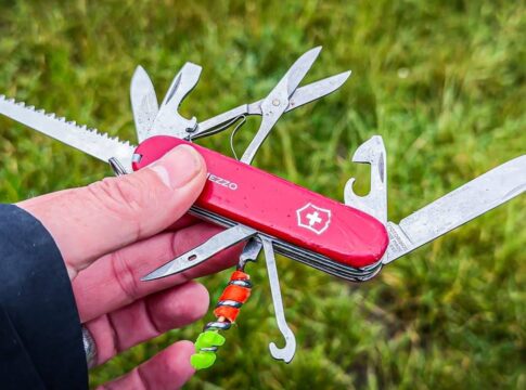 A Swiss Army Knife held in a hand, showcasing multiple tools including blades and scissors