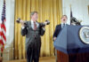 U.S. President Ronald Reagan lifting dumbbells during a press conference with laughter