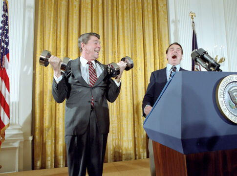 U.S. President Ronald Reagan lifting dumbbells during a press conference with laughter