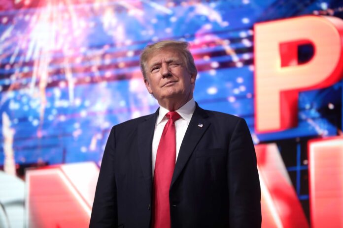 A man in a suit in front of fireworks.