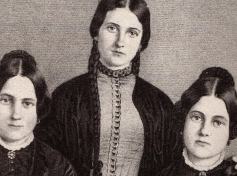 Black and white portrait of three women, the Fox Sisters, standing closely together