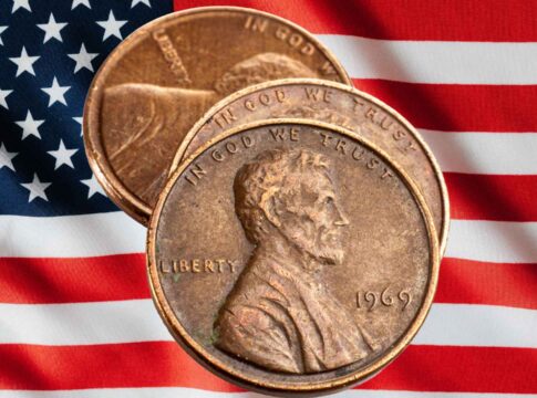 Three Lincoln pennies on a background of the American flag
