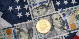 American flag background with hundred dollar bills and coin