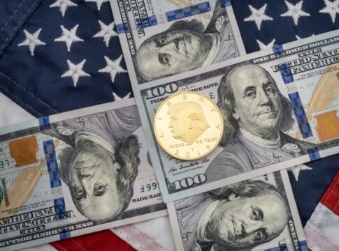 American flag background with hundred dollar bills and coin