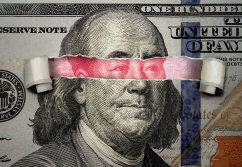 Torn dollar revealing Chinese yuan behind Benjamin Franklins eyes.