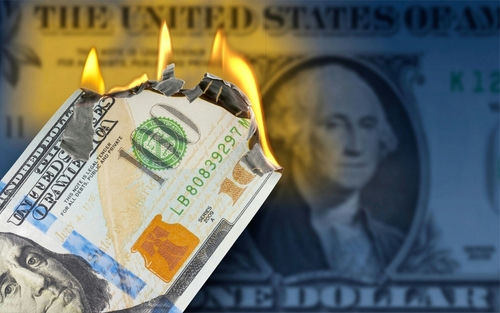 Burning US hundred-dollar bill with flames at the corner
