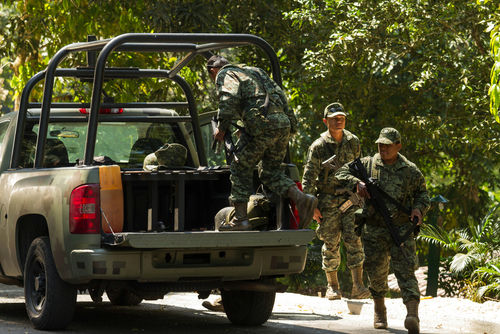 shutterstock296310842-1jpg Soldiers loading equipment into a military vehicle in forest.
