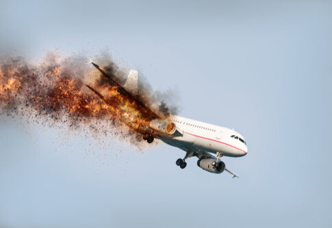 An airplane experiencing an explosion mid-flight with smoke and fire trailing behind