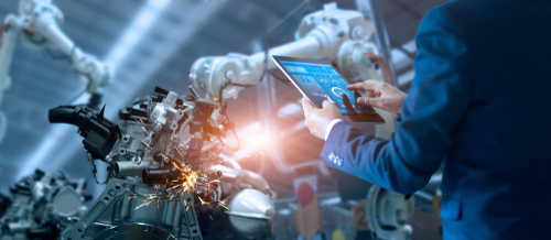 shutterstock_1119927341.jpg featured image Person using a tablet to monitor robotic machinery.