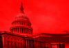 United States Capitol building under red-hued sky.