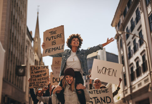 Women at protest holding feminist signs.