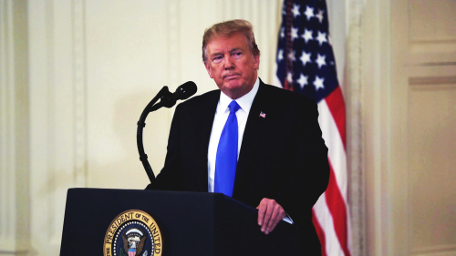 shutterstock_1326218579.jpg featured image Donald Trump speaking at a podium with American flag.