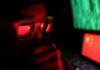 Person wearing glasses reflecting Chinese flag, green code.