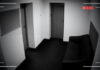 CCTV footage of an empty hallway with doors and sofa.