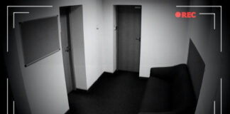 CCTV footage of an empty hallway with doors and sofa.