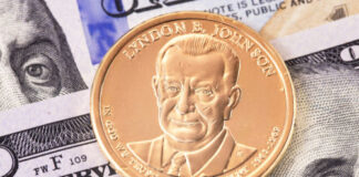 Lyndon B. Johnson coin on top of dollar bills.