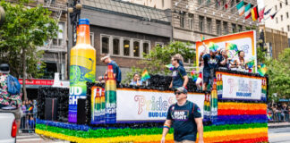 Pride parade float with rainbow colors and Bud Light logos.
