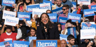 Person speaking at a rally with supporting crowd