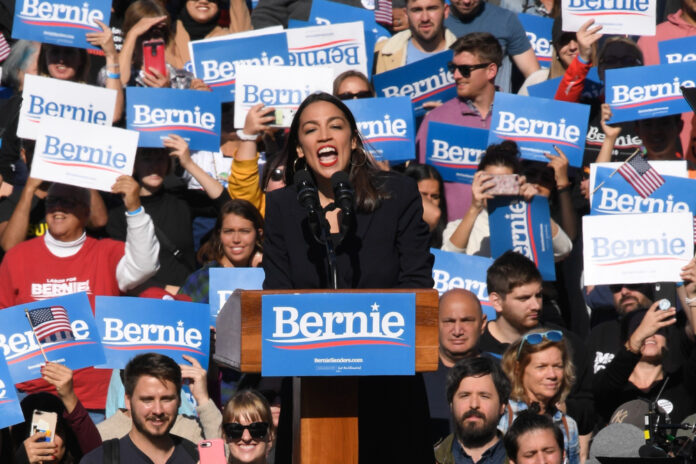 Person speaking at a rally with supporting crowd