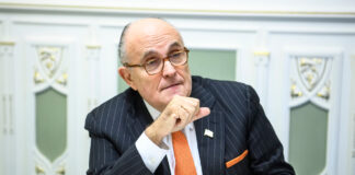 Rudy Giuliani Man in suit sitting at a table indoors