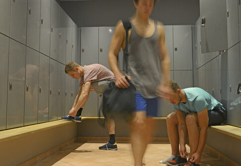 Men in a gym locker room preparing for a workout