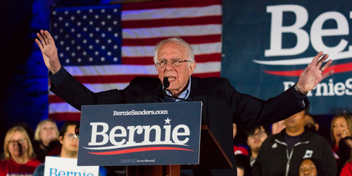 shutterstock_1666673332.jpg featured image Bernie Sanders speaking at a rally with arms raised.