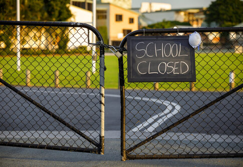 School closed sign on a gated fence.