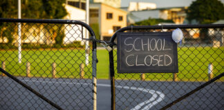 School closed sign on a gated fence.