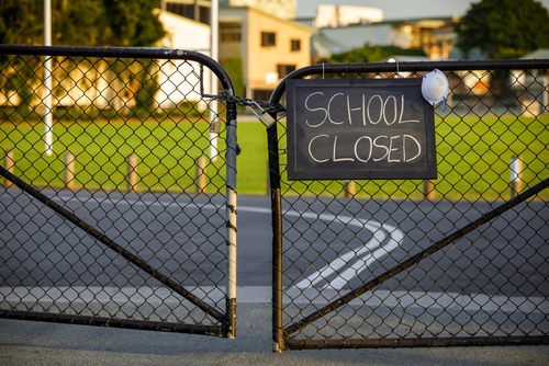 School closed sign on a gated fence.