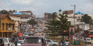 Busy street in an urban area with cars and motorcycles.