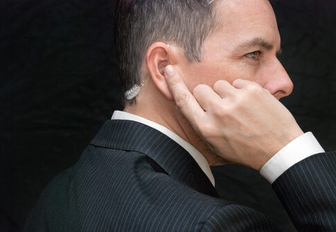 Man in suit with earpiece, looking serious.