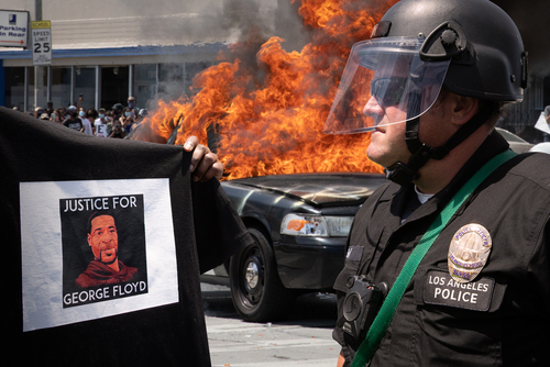 Protester with George Floyd shirt, police officer, burning vehicle.