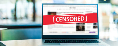 Laptop screen with CENSORED banner over webpage