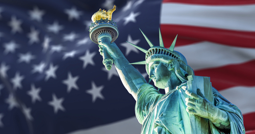 shutterstock_1919883632.jpg featured image Statue of Liberty with American flag background.