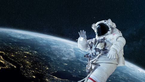 Astronaut floating in space above Earth, waving.