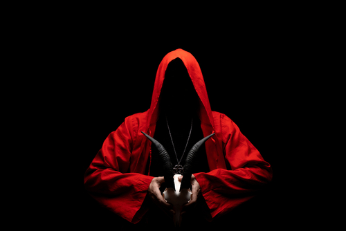 shutterstock_1937154697.jpg featured image Hooded figure in red cloak holding a goat skull.