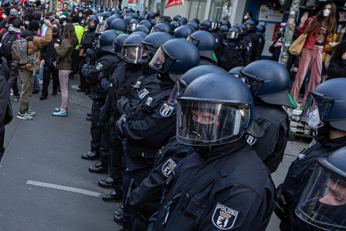 Riot police officers in line during a public protest.