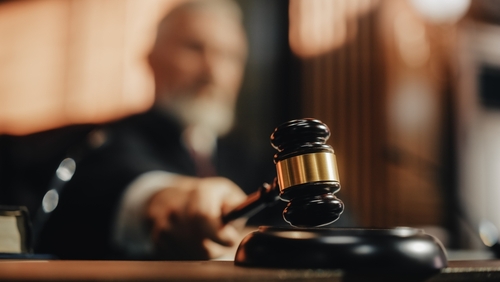 shutterstock_2056414424 (2).jpg featured image Judge striking gavel in courtroom.
