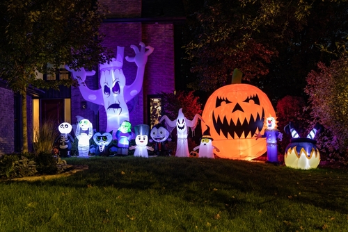 Inflatable Halloween decorations in yard at night.