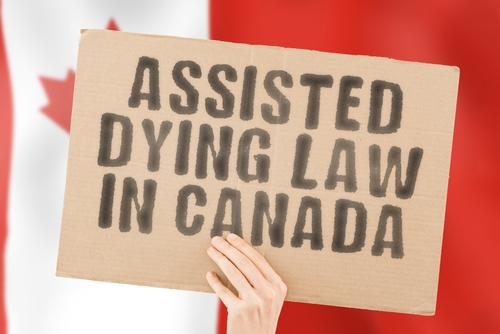 Hand holding sign Assisted Dying Law in Canada.